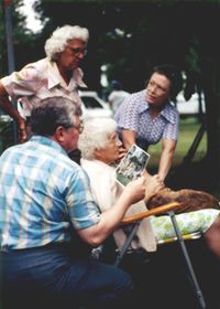 (Left to right) Dad, Aunt Marie, Grandma, and Aunt Edith at the Gumnick Family Reunion 1986. Dad is holding a photo taken at a previous family reunion, I think.